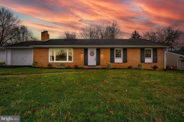 single story home with a garage and a yard