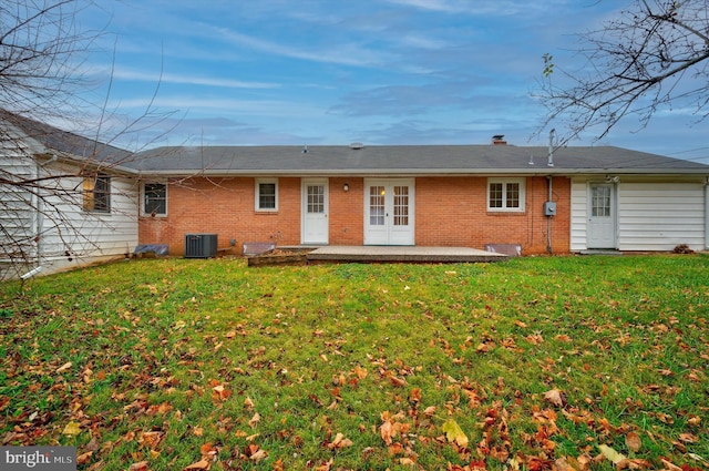 back of property featuring french doors, a yard, a patio, and central AC