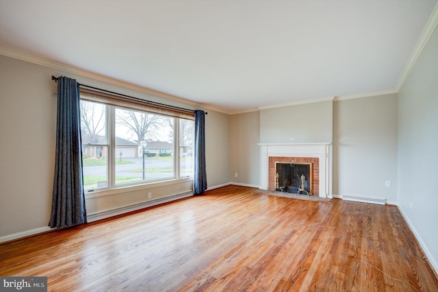 unfurnished living room featuring light hardwood / wood-style floors, crown molding, a fireplace, and a baseboard radiator