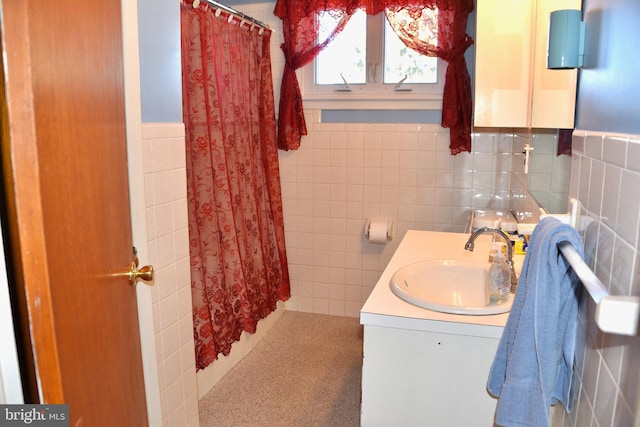 bathroom with vanity and tile walls