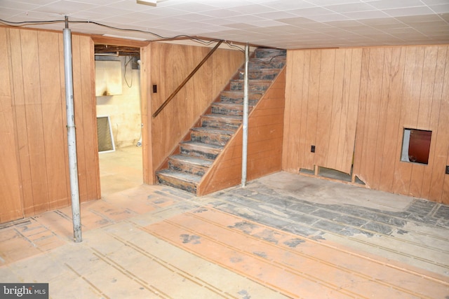 basement featuring wooden walls