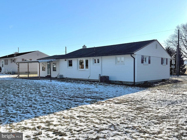 snow covered house featuring central air condition unit