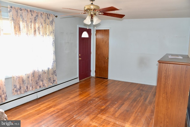 spare room with wood-type flooring, baseboard heating, and ceiling fan