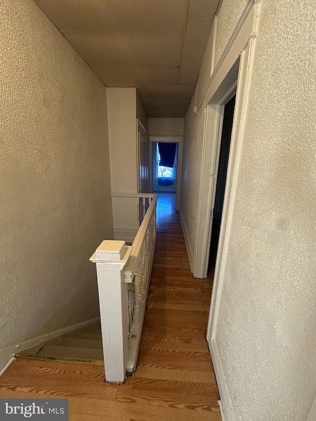 hallway with hardwood / wood-style floors