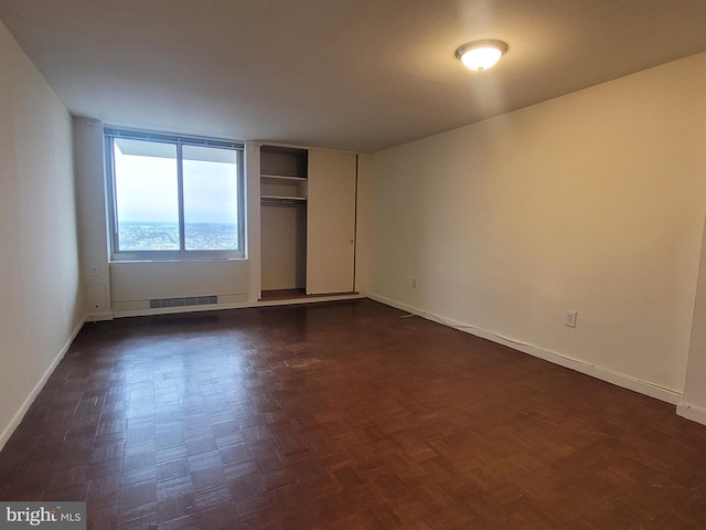 unfurnished bedroom featuring dark parquet floors