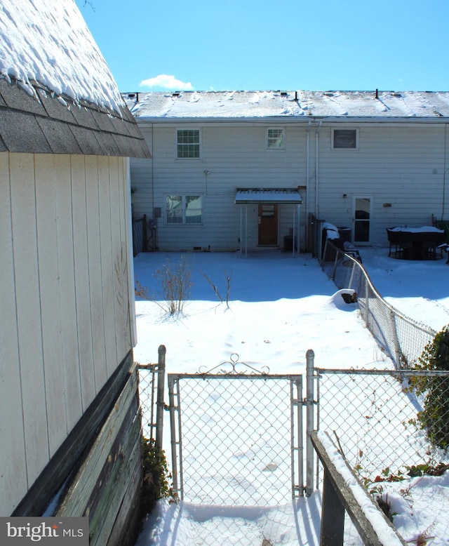 view of snow covered rear of property