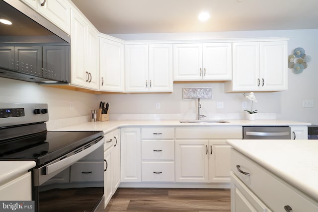 kitchen featuring sink, white cabinetry, stainless steel appliances, and dark wood-type flooring