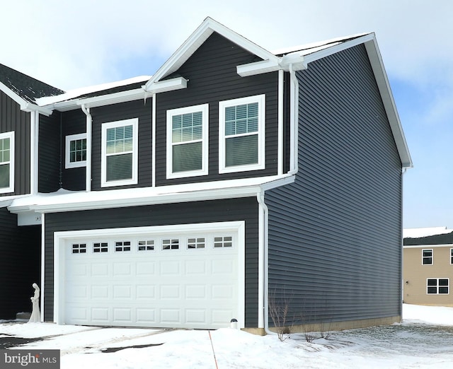 view of snow covered exterior with a garage