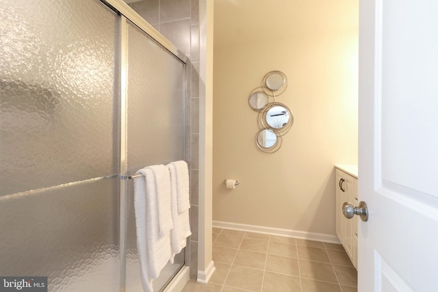 bathroom featuring a shower with door, vanity, and tile patterned flooring