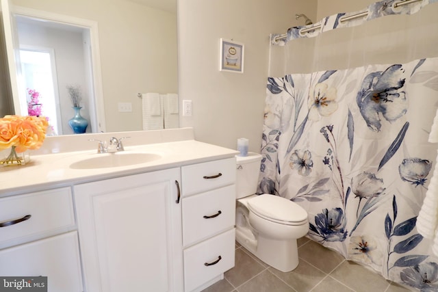 bathroom featuring tile patterned flooring, vanity, a shower with shower curtain, and toilet