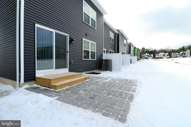 snow covered property with cooling unit