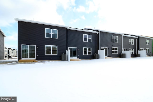 snow covered property featuring central AC