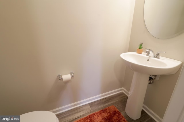 bathroom featuring wood-type flooring and toilet