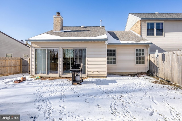 view of snow covered rear of property