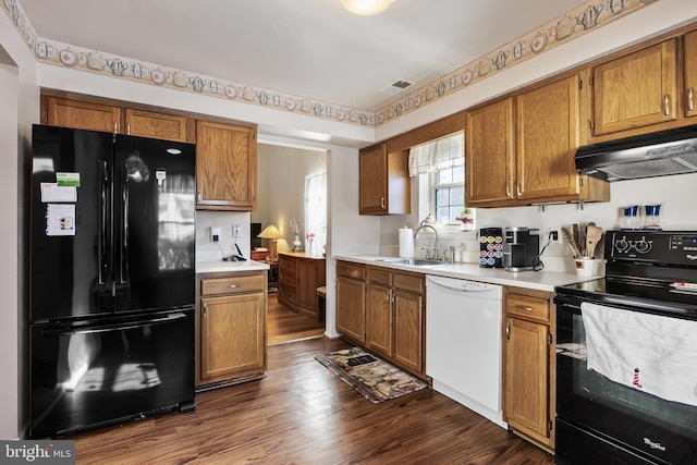 kitchen with sink, dark hardwood / wood-style floors, and black appliances