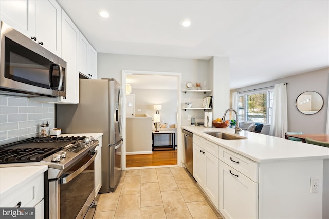 kitchen with white cabinetry, sink, stainless steel appliances, backsplash, and light tile patterned flooring