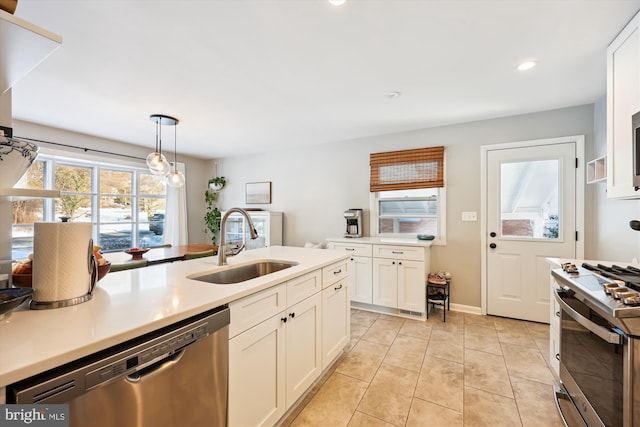 kitchen with white cabinetry, sink, pendant lighting, light tile patterned flooring, and appliances with stainless steel finishes