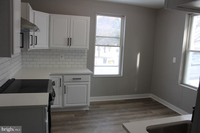 kitchen with decorative backsplash, extractor fan, white cabinets, dark hardwood / wood-style floors, and black range with electric stovetop