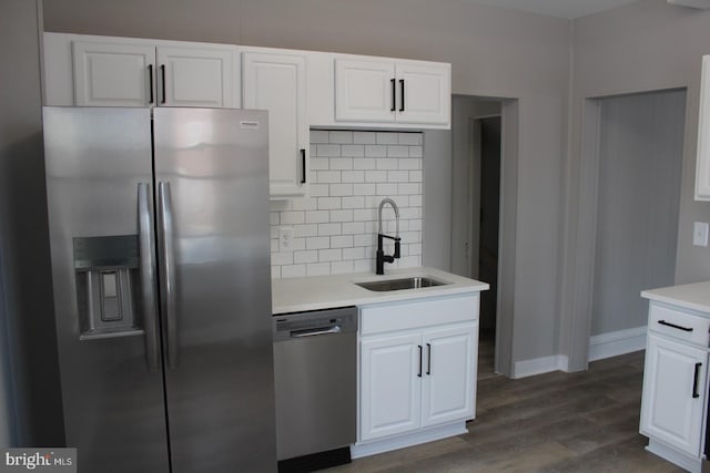 kitchen featuring sink, dark hardwood / wood-style floors, backsplash, white cabinets, and appliances with stainless steel finishes