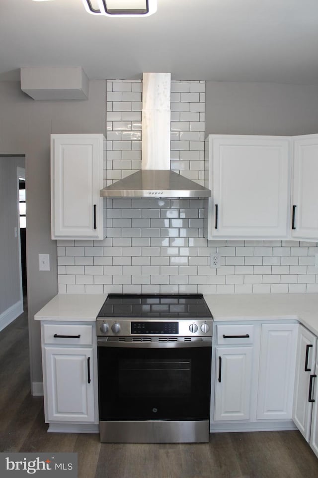 kitchen featuring tasteful backsplash, white cabinetry, wall chimney exhaust hood, and stainless steel range oven