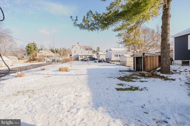 yard covered in snow featuring a shed