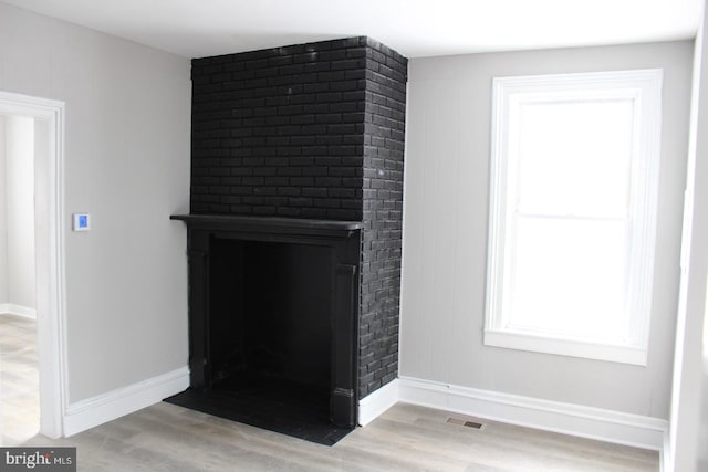 interior details with a large fireplace and wood-type flooring