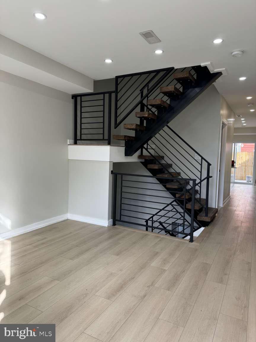 stairway with hardwood / wood-style floors