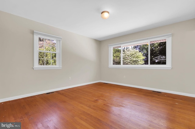 spare room with plenty of natural light, hardwood / wood-style floors, and baseboards