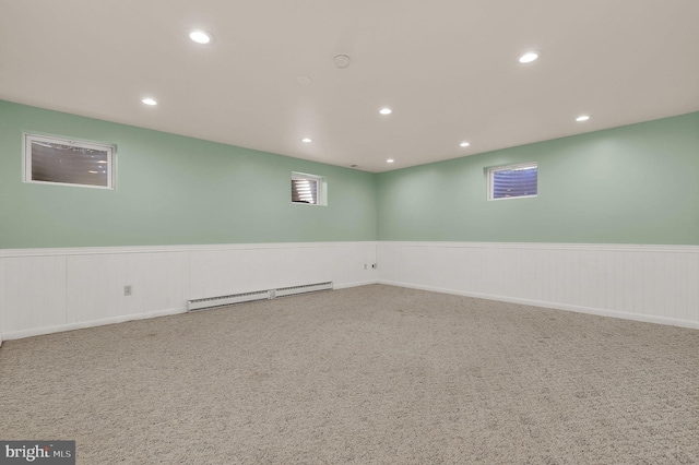 below grade area featuring baseboard heating, a wainscoted wall, recessed lighting, and carpet