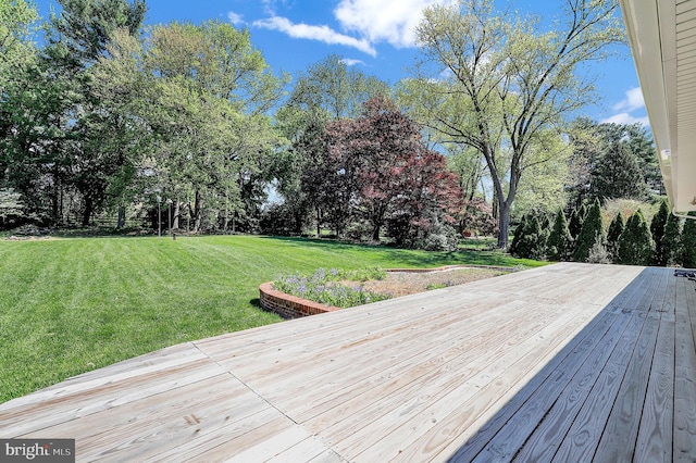 wooden deck with a lawn and view of scattered trees