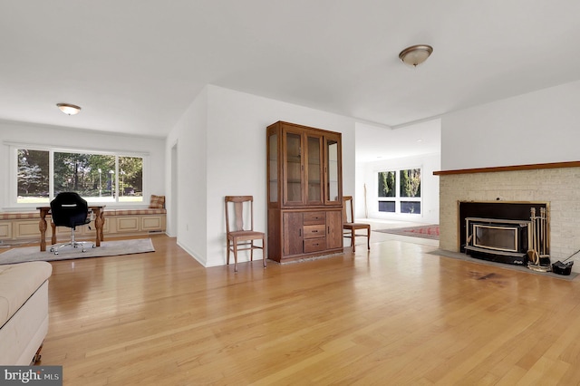 living room featuring light wood-type flooring, plenty of natural light, and a desk