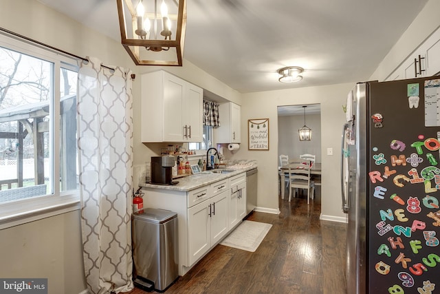 kitchen featuring pendant lighting, sink, white cabinetry, and stainless steel appliances