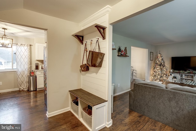 mudroom with dark hardwood / wood-style floors and a chandelier