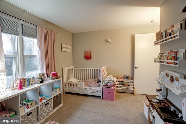 bedroom featuring carpet floors and a nursery area