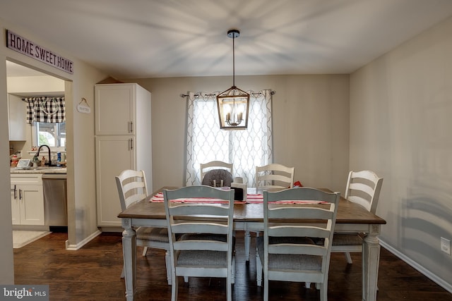 dining area featuring dark hardwood / wood-style flooring, sink, and an inviting chandelier