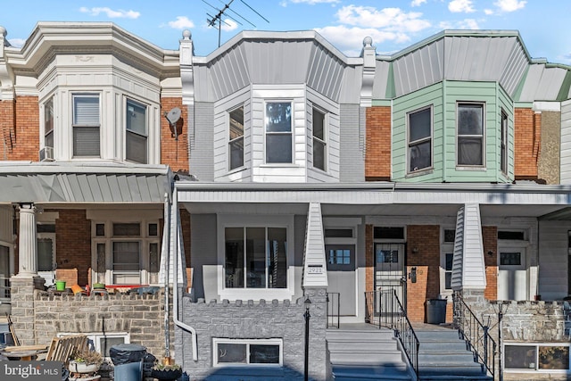 townhome / multi-family property featuring covered porch