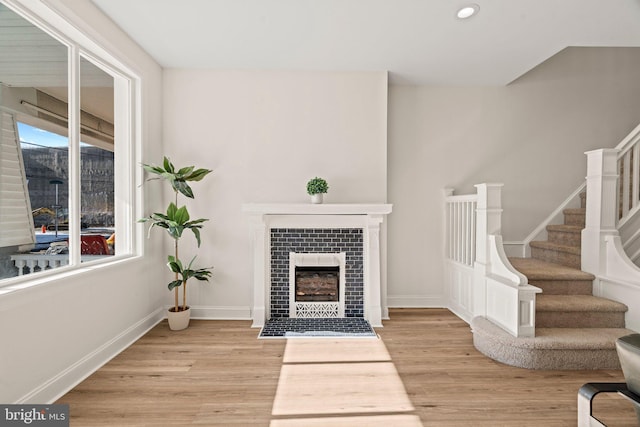 living room featuring a fireplace and light wood-type flooring