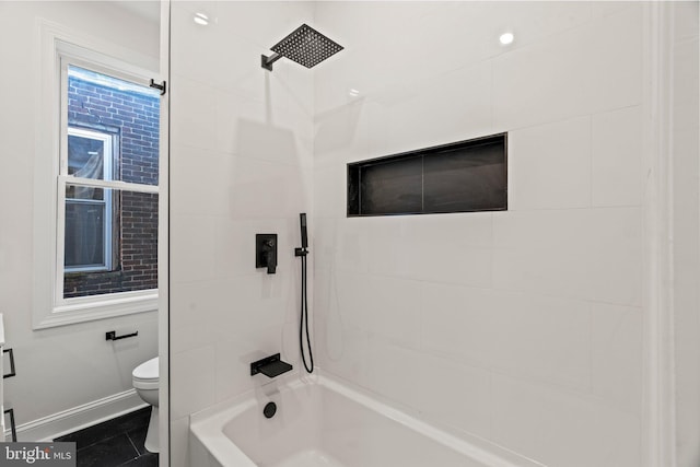 bathroom featuring tile patterned floors, toilet, and tiled shower / bath