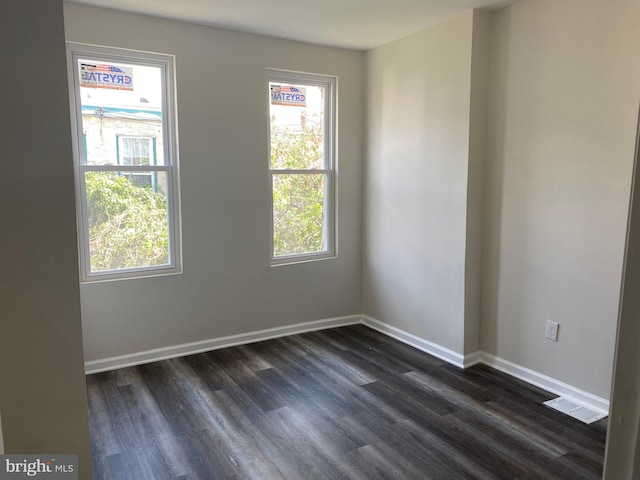 unfurnished room with dark wood-type flooring