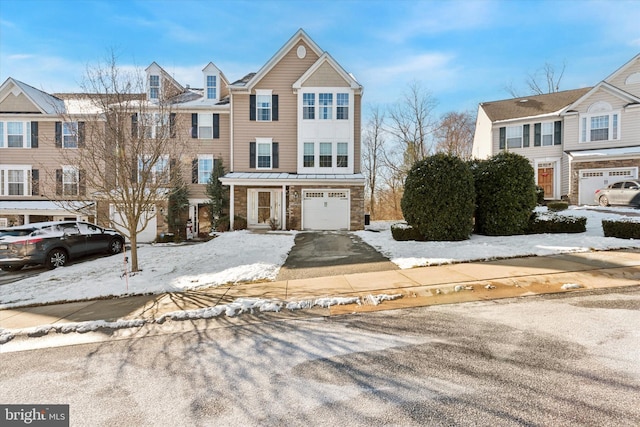 multi unit property with stone siding and an attached garage