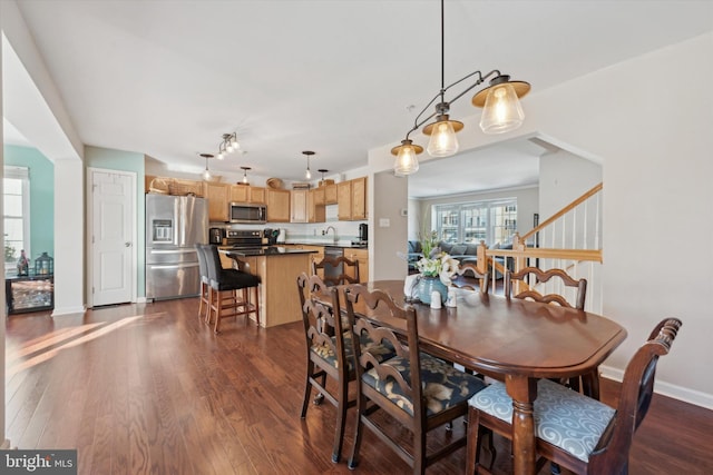 dining area featuring dark wood-style floors, stairway, and baseboards