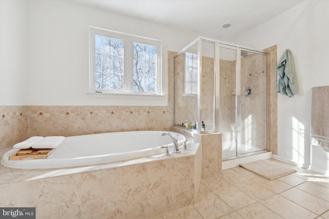 bathroom with a stall shower, a garden tub, and tile patterned floors