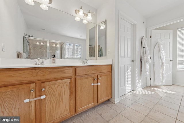 bathroom with double vanity, tile patterned flooring, a sink, and a shower stall