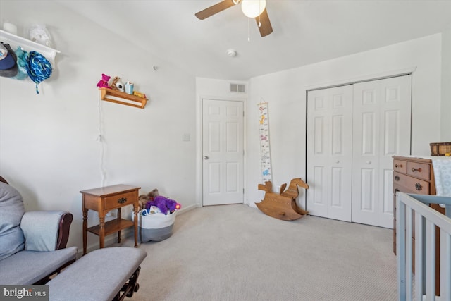 bedroom featuring carpet floors, ceiling fan, visible vents, and a closet