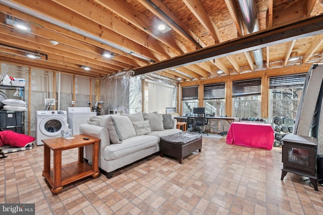 living room with washer and clothes dryer, brick floor, and a wood stove