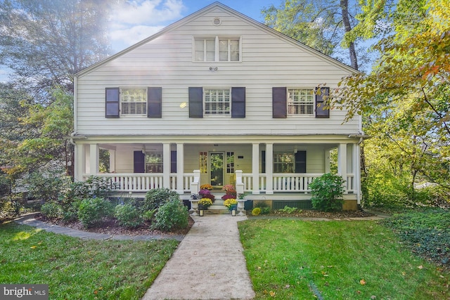 view of front of property featuring covered porch and a front lawn