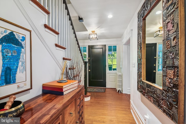 foyer featuring hardwood / wood-style flooring and radiator heating unit