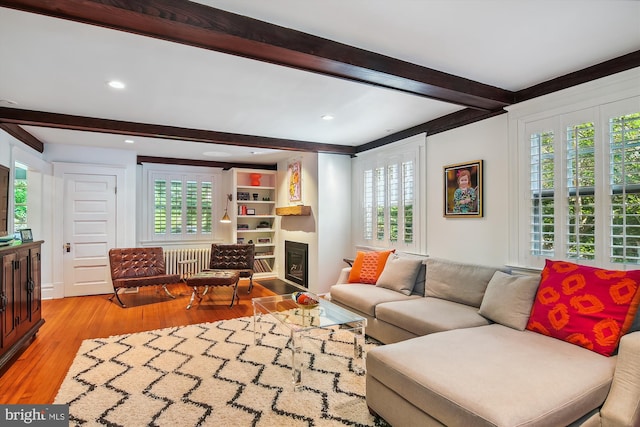 living room featuring light hardwood / wood-style flooring and beam ceiling