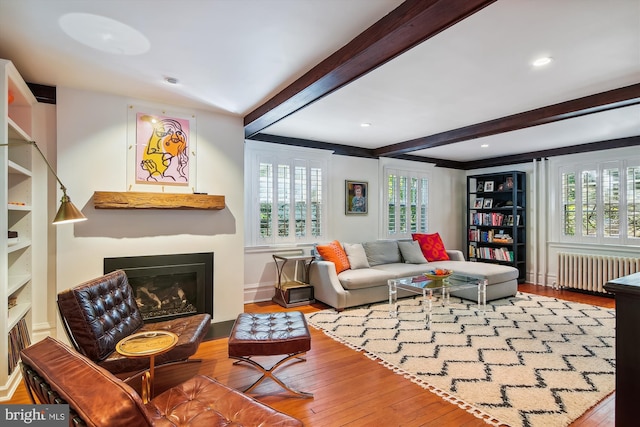 living room with hardwood / wood-style flooring, plenty of natural light, radiator, and beam ceiling