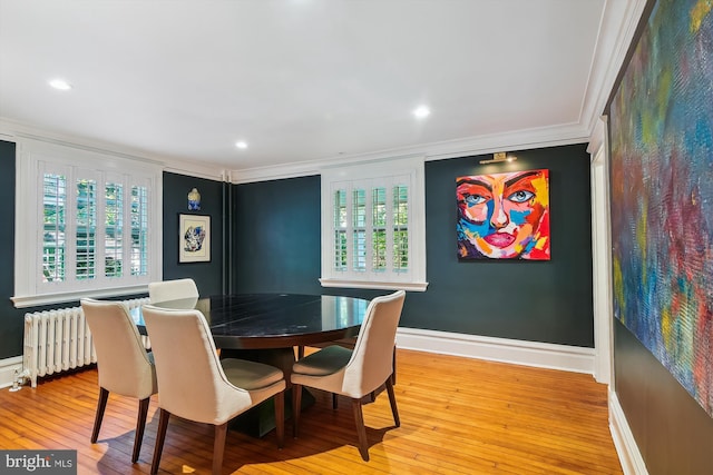 dining room featuring radiator, crown molding, and light hardwood / wood-style flooring